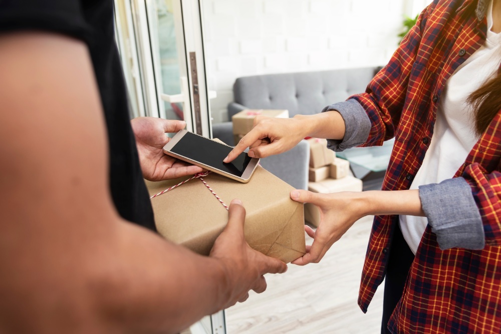 Person receiving package with phone